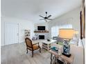 Bright living room features vaulted ceilings, a ceiling fan, wood-look floors and a decorative fireplace at 260 Killarney Bay Ct # 6-6, Winter Park, FL 32789
