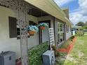 Inviting front porch with hanging flower baskets, decorative plants, and updated windows at 2648 Amsden Rd, Winter Park, FL 32792