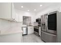 Modern kitchen with stainless steel appliances, white cabinets, and a stylish backsplash at 3030 Clubview Dr # Ge, Orlando, FL 32822