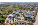 Aerial view of apartment complex with a pond, pool and many trees at 3176 Feltrim Pl # 302, Kissimmee, FL 34747