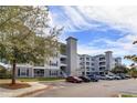 Apartment building featuring a parking lot and view of blue sky at 3176 Feltrim Pl # 302, Kissimmee, FL 34747