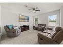 Bright living room with ceiling fan, multiple windows, comfortable seating, and a TV for entertainment at 3537 Seneca Club Loop # B, Orlando, FL 32808