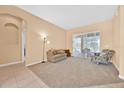 Bright living room featuring neutral paint, plush carpeting, and sliding glass doors at 3954 Old Dunn Rd, Apopka, FL 32712