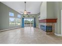 Spacious living room showcasing a fireplace, tile flooring, and natural light from large windows at 3966 Villas Green, Longwood, FL 32779