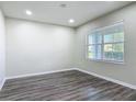 Bright bedroom with wood-look floors, neutral paint, and large window providing ample natural light at 3975 Silverstream Ter, Sanford, FL 32771