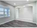 Bright living room with an archway and wood-look flooring at the entry at 3975 Silverstream Ter, Sanford, FL 32771