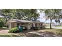 View of a single-story home featuring a covered parking area, landscaped lawn, and quaint curb appeal at 401 Sunny Ct, Fruitland Park, FL 34731