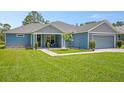 Inviting single-story home with a well-maintained lawn and a cozy front porch seating area at 5531 Marys Villa Rd, Groveland, FL 34736