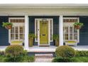 Inviting front porch featuring a bright green door, hanging plants, and stylish seating at 6047 Blakeford Dr, Windermere, FL 34786