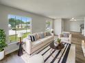 Bright living room featuring neutral tones, large windows, stylish decor, and wood laminate flooring at 7040 Hennepin Blvd, Orlando, FL 32818