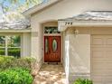 Close-up of front door with glass detailing and number above it on a home with well-kept landscaping at 748 Andover Cir, Winter Springs, FL 32708