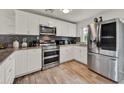 Modern kitchen featuring stainless steel appliances, granite countertops, and white cabinets at 7807 Pine Hawk Ln, Orlando, FL 32822