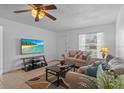Cozy living room featuring tile floors, comfortable seating, a ceiling fan, and a mounted TV for modern living at 8116 Parrot Dr, Orlando, FL 32825