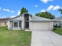 Well-maintained single-story home with a two-car garage and a green lawn at 826 Long Bay Ct, Kissimmee, FL 34741