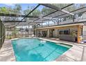 Inviting screened-in pool area with a spacious patio, hot tub, and lush landscaping at 8308 Granada Blvd, Orlando, FL 32836