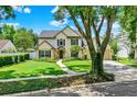 Inviting two-story home with a lush front lawn, mature landscaping, and a classic architectural design at 991 Hawthorne Cove Ct, Ocoee, FL 34761