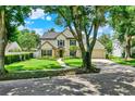 Beautiful two-story home with mature shade tree, landscaped yard, and a walkway leading to the front entrance at 991 Hawthorne Cove Ct, Ocoee, FL 34761