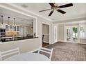 Open floor plan with brick flooring, ceiling fan, and breakfast bar overlooking the kitchen at 991 Hawthorne Cove Ct, Ocoee, FL 34761