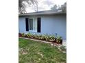 Charming exterior featuring black shutters, well-kept grass, and manicured garden bed at 1000 Sal St, Ocoee, FL 34761