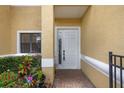 Close-up view of the home entrance featuring a well-lit entryway, garden, and modern white door at 1434 Pacific Rd, Kissimmee, FL 34759