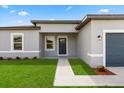 Inviting front entrance featuring a modern door, freshly cut lawn, and neutral toned exterior at 14905 Sw 39Th Cir, Ocala, FL 34473