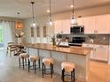 Well-appointed kitchen featuring a large island with seating and modern stainless steel appliances at 17319 Million Lakes Ct, Clermont, FL 34714