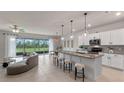 Bright, open-concept kitchen featuring a spacious island, modern appliances, and seamless access to an outdoor patio at 17319 Million Lakes Ct, Clermont, FL 34714