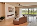 Bright living room boasts neutral tones, decorative fireplace and a serene view of the outdoors at 17319 Million Lakes Ct, Clermont, FL 34714