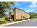 Exterior view of tan townhome featuring screened in patio and lush landscaping at 2011 Crestdale Ln, Lake Mary, FL 32746