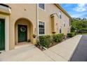 Charming front entryway with a green door, decorative wreath, and manicured shrubs at 2011 Crestdale Ln, Lake Mary, FL 32746