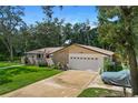 Charming single-story home featuring a brick facade, lush green lawn, and mature trees under a bright, sunny sky at 203 N Sweetwater Blvd, Longwood, FL 32779