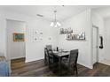 Dining area boasts modern light fixture and decorative shelves with Gathering photos for a personal touch at 2628 Balforn Tower Way, Winter Garden, FL 34787