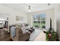 Bright living room features a ceiling fan and sliding glass doors that provides access to the backyard at 2628 Balforn Tower Way, Winter Garden, FL 34787