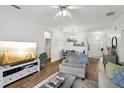 Open concept living area offers wood flooring, natural light, and a cozy atmosphere for relaxation at 2628 Balforn Tower Way, Winter Garden, FL 34787