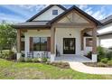 Inviting front porch featuring rocking chairs, wood beams, and a stylish entrance at 27071 Moss View Dr, Tavares, FL 32778