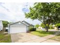 Residential house featuring well-maintained lawn, mature tree and a two-car garage at 302 Cello Cir, Winter Springs, FL 32708