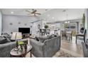 Open-concept living room with modern furnishings, neutral tones, and plenty of natural light at 3043 Mapleshade St, Deltona, FL 32738