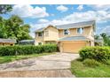 View of the home's driveway, garage, rear elevation, and lush, mature landscaping at 3102 Cecelia Dr, Apopka, FL 32703