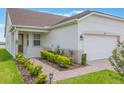 Inviting single-story home with a well-maintained lawn, manicured landscaping, and an attached two-car garage at 3240 Canna Lily Pl, Clermont, FL 34711