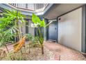 Courtyard view with tropical plants and brick pavers leading to the unit's front door for convenient access at 3887 Atrium Dr # 3, Orlando, FL 32822