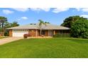 Charming single-story brick home with a well-manicured lawn and a two-car garage with beautiful landscaping at 428 N Pine Meadow Dr, Debary, FL 32713