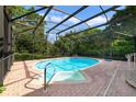 Screened-in pool with brick patio is surrounded by lush greenery for ultimate privacy and outdoor enjoyment at 428 N Pine Meadow Dr, Debary, FL 32713