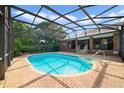 Screened-in pool with brick patio is surrounded by lush greenery for ultimate privacy and outdoor enjoyment at 428 N Pine Meadow Dr, Debary, FL 32713