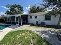 View of the backyard with a screened-in patio and mature trees at 4534 Lemans Dr, Orlando, FL 32808