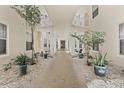 Picturesque walkway with stone floor and white columns with plants and trees at 4650 Links Village Dr # B103, Ponce Inlet, FL 32127