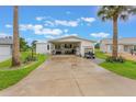 Bright home featuring a spacious driveway flanked by palm trees and well-maintained landscaping at 5305 Ingleside, Leesburg, FL 34748