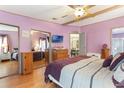 Spacious bedroom featuring an en suite bathroom, closet with mirrored doors, and laminate wood flooring at 5305 Ingleside, Leesburg, FL 34748