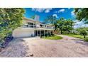 View of home showcasing multi-level deck, lush landscaping, and brick driveway for a beautiful curb appeal at 625 Woodlawn Cemetery Rd, Gotha, FL 34734