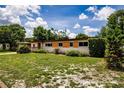 Single-story home with manicured lawn and decorative shrubbery, offering a cozy, welcoming facade at 6310 Lake Underhill Rd, Orlando, FL 32807