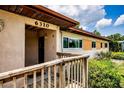 Inviting front porch with wooden railing and a glimpse of the home's exterior details at 6310 Lake Underhill Rd, Orlando, FL 32807